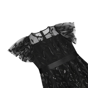Close-up of black mesh dress featuring leaf embroidery, sequins, and a satin belt