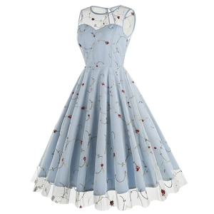 Détail de la broderie florale rouge et de la maille fine sur la robe vintage bleu clair
