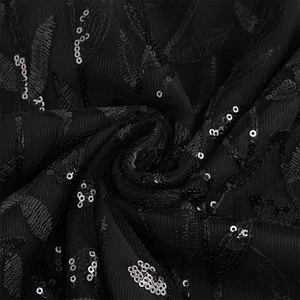 Detail of black mesh fabric with sequin embroidery and leaf patterns on a retro dress