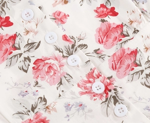 Detailed macro view of retro rose floral print fabric with white buttons and smooth texture