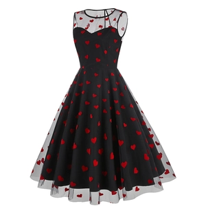 Détail d'une robe rétro sans manches avec décolleté en mesh et broderie cœur rouge sur noir