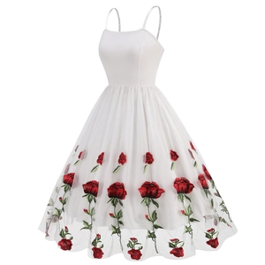 Close-up of red rose embroidery on a white mesh vintage cocktail dress with straps