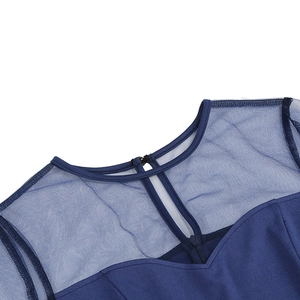 Détail de robe bleu foncé avec empiècement en résille et bouton à l'encolure