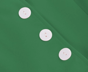 Close-up of white round buttons on green textured fabric of a vintage summer dress
