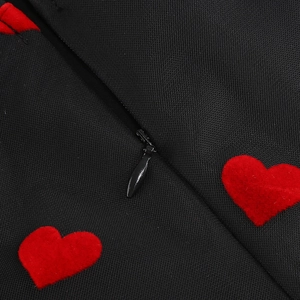 Détail de la fermeture éclair invisible et des cœurs rouges sur la robe noire