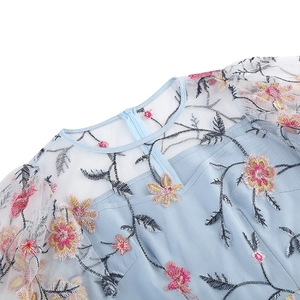 Detail view of floral embroidery on light blue dress with sheer mesh neckline and zipper