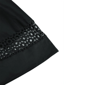 Close-up of intricate circular lace trim on the black cotton cocktail dress hem
