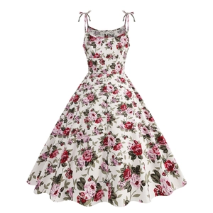 Detail of vintage floral cocktail dress featuring adjustable bow straps and rose print