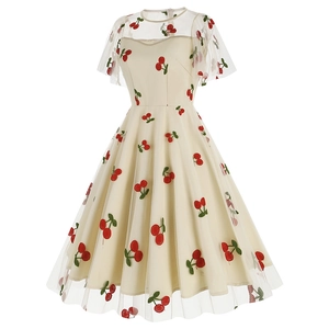 Détail de la robe vintage en tulle avec broderies de cerises rouges et tissu en résille