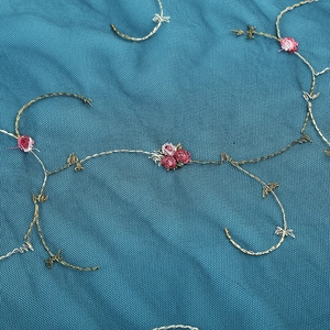 Gros plan détaillé de broderies florales vintage sur tulle bleu foncé pour robe