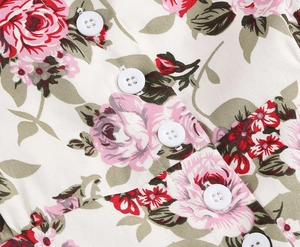 Detailed macro view of white resin buttons and pink rose floral print on a retro dress