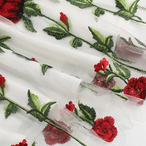 Détail de la broderie de roses rouges sur tulle blanc pour robe de soirée vintage