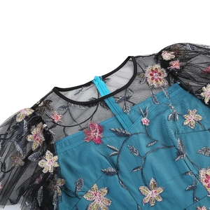 Close-up of floral embroidery on mesh fabric with hidden zipper and puff sleeves