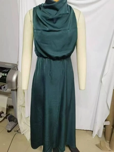 Detail of elegant dark green satin sleeveless dress showing smooth fabric texture and drape