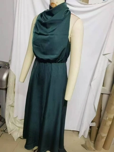 Detailed view of dark green satin sleeveless dress with a draped cowl neck on a mannequin