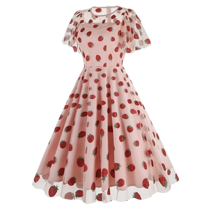 Détail de la robe en tulle rose avec broderie de fraises rouges et volants légers