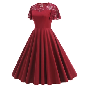Détail de la dentelle rouge délicate et du col rond sur une robe de cocktail vintage trapèze