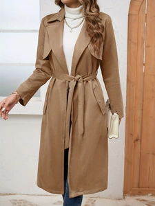Detail view of the notch lapel and buckled pockets on this brown faux suede trench coat