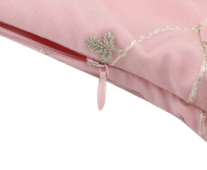 Detailed close-up of pink fabric featuring delicate silver embroidery and hidden zipper