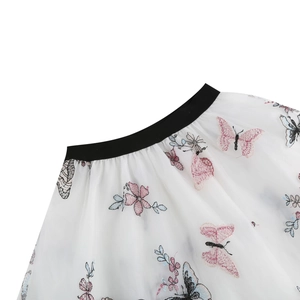Broderies détaillées de papillons colorés et motifs floraux sur tulle blanc de la jupe