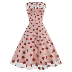 Détail du tissu en tulle rose avec des motifs de fraises rouges brodés sur une robe