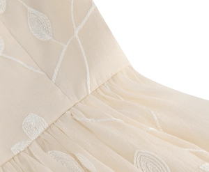 Details von weißen Blattstickereien und Falten am beigen Chiffon-Cocktailkleid