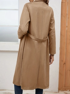 Back view of a camel suede long trench coat with a matching waist belt and sleek design