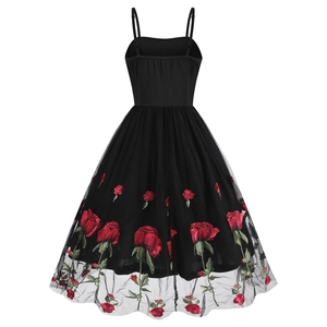 Detail view of the back side of a vintage black dress with rose embroidery and mesh layers