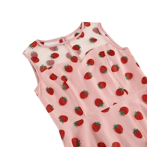 Détail du décolleté de robe rose avec empiècement en mesh et broderies de fraises brillantes