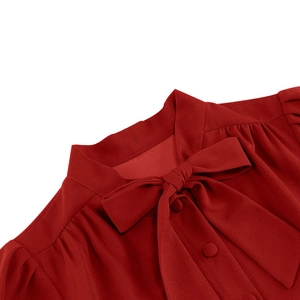 Détail du col à nœud et des boutons sur une robe vintage rouge foncé chic