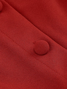 Gros plan sur la texture du tissu crêpe rouge et les boutons recouverts assortis de la robe