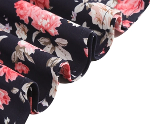 Detail view of pink rose floral print on a retro black dress with quality hem stitching