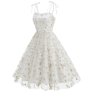 Detailed close-up of pink floral embroidery on white tulle dress with adjustable strap