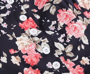 Macro detail of retro floral print fabric with white buttons on a vintage cocktail dress