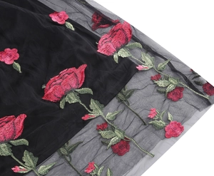 Detail of red rose embroidery on black mesh fabric for a vintage cocktail dress