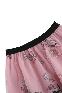 Détail de jupe en tulle rose avec broderie de papillons colorés et ceinture élastique noire