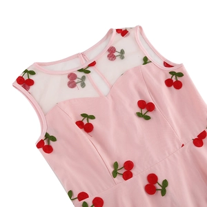 Détail de la robe rose vintage montrant l'encolure en tulle et la broderie cerise