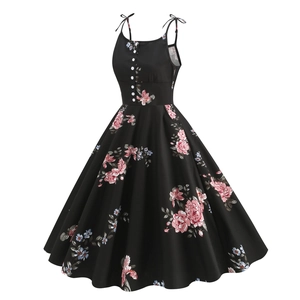Close-up of retro black floral dress with bow shoulder straps and white buttons