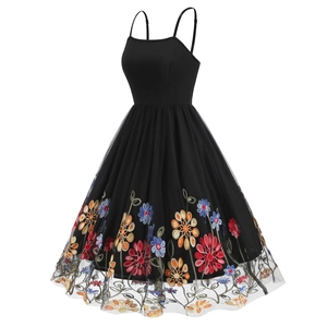 Detail of colorful floral embroidery on black mesh skirt of vintage cocktail dress