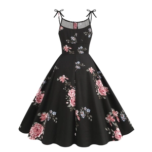 Detail of vintage floral A-line dress featuring bow shoulder straps and a cinched waistline