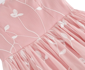 Detail der Blattstickerei und der plissierten Taille an einem rosa Cocktailkleid