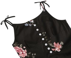 Close-up of floral print vintage dress with white buttons and tie-up shoulder straps