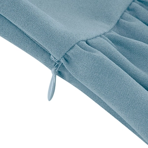 Détail de la fermeture éclair invisible et du tissu bleu clair texturé sur la robe