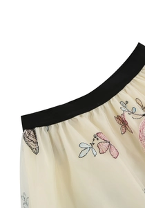 Détail de broderie de papillons sur jupe en tulle vintage avec taille élastique large