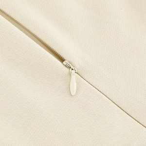 Détail de la fermeture éclair invisible sur le tissu beige de la robe rétro des années 50
