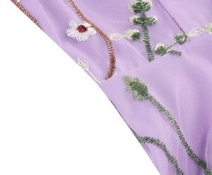 Detail of floral embroidery on light purple mesh fabric of this elegant 50s dress