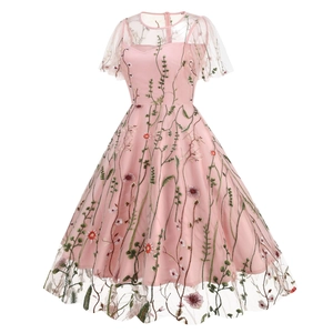 Detailed close-up of intricate floral embroidery on pink mesh vintage dress fabric