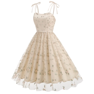 Close-up of pink floral embroidery and mesh layering on the champagne retro dress