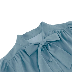 Détail d'un col à lavallière élégant avec boutons recouverts sur une robe bleue