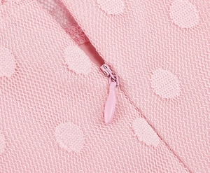 Macro shot of pink polka dot mesh fabric with high-quality invisible teardrop zipper